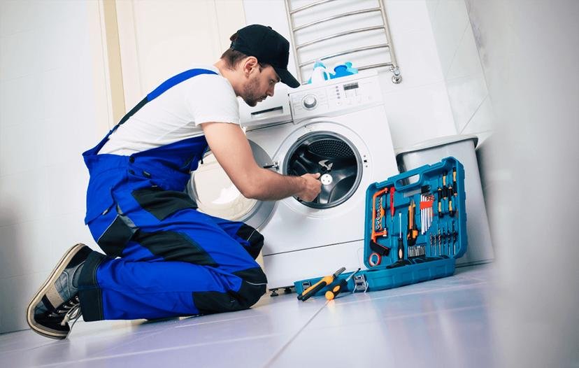 Sceptre technician kneeling to repair a washing machine